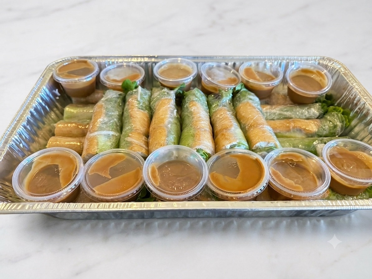 A Phở Rolls catering tray of fresh spring rolls with peanut sauce cups