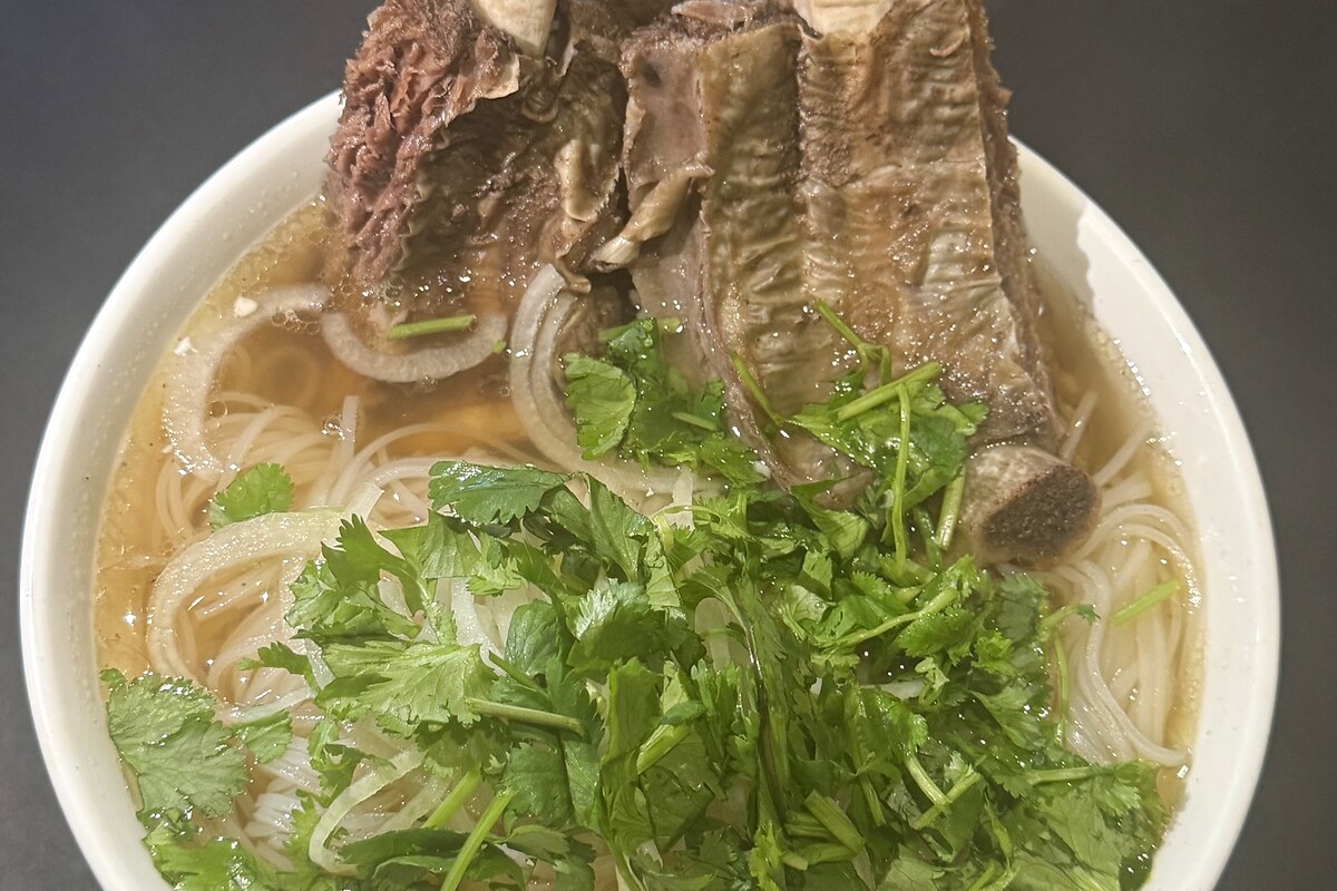 Phở bowl with beef ribs, noodles, cilantro, and herbs
