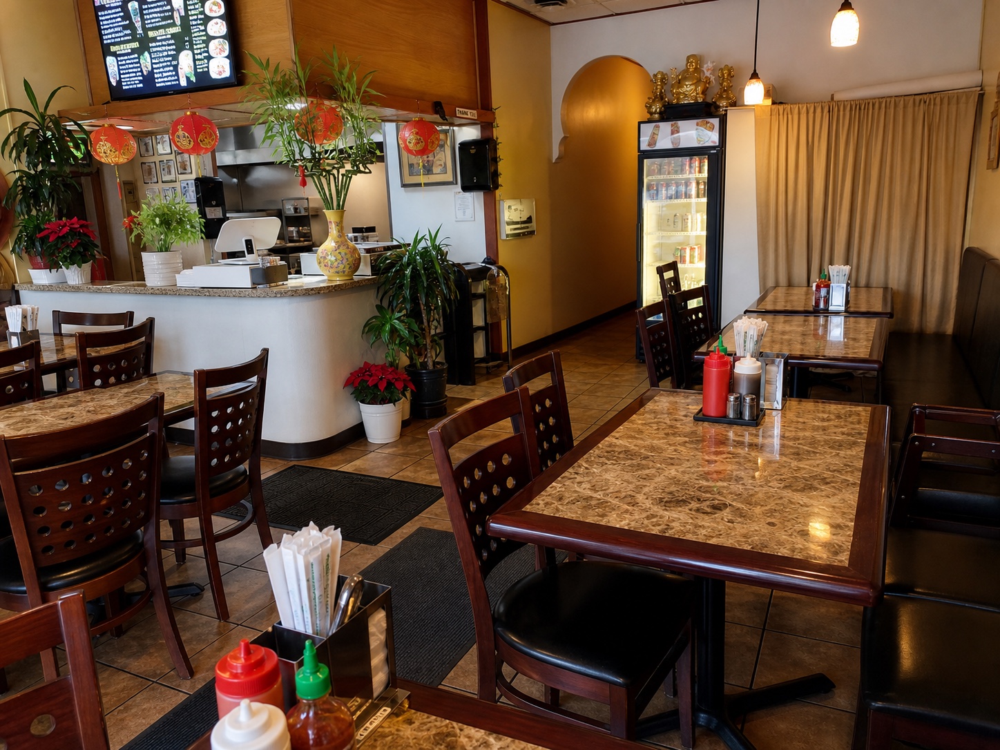 The Phở Rolls dining room and counter in Renton, with polished tables, plants, and warm pendant lights